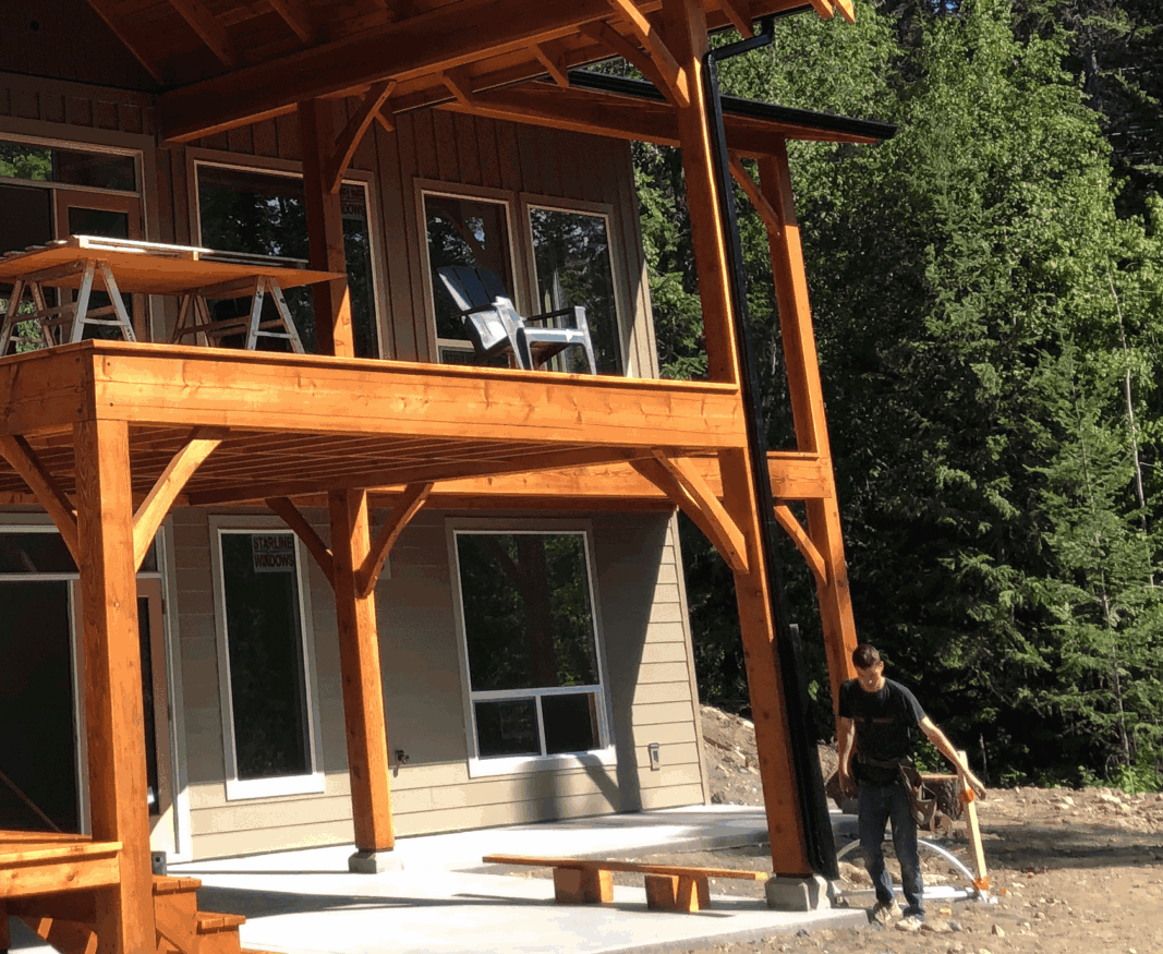 Professional using safety gear while cleaning gutters on a multi-story Okanagan home
